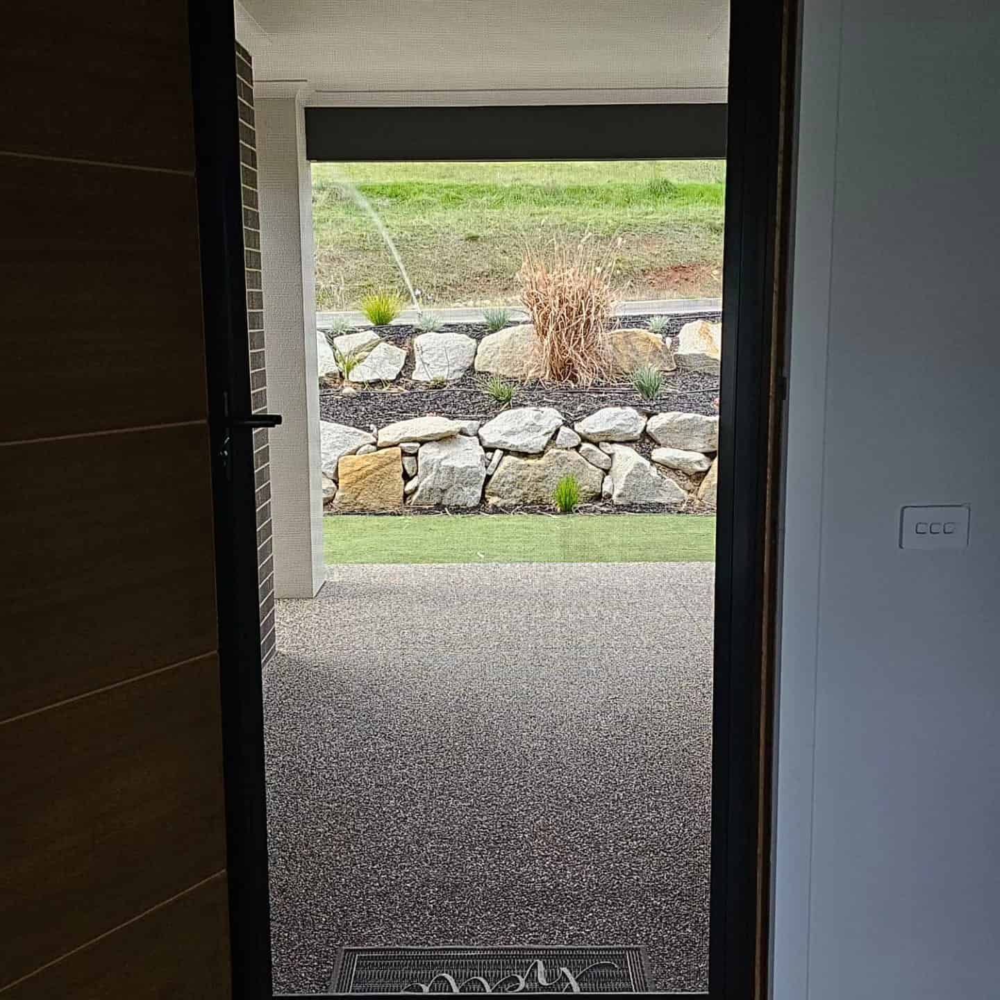 A Door With A View Of A Stone Wall — Border Security Doors & Powder Coating in Wodonga, VIC