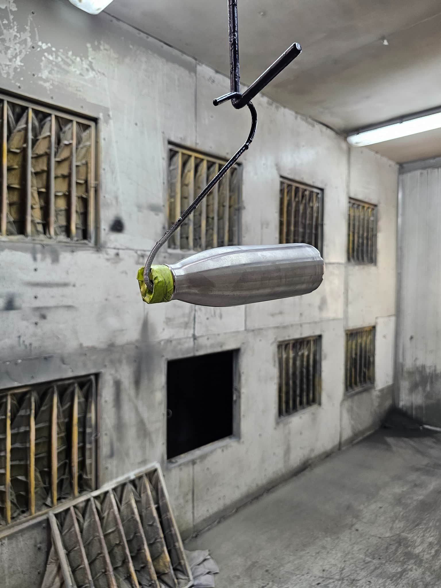 A Bottle Is Hanging From The Ceiling In A Room — Border Security Doors & Powder Coating in Wodonga, VIC