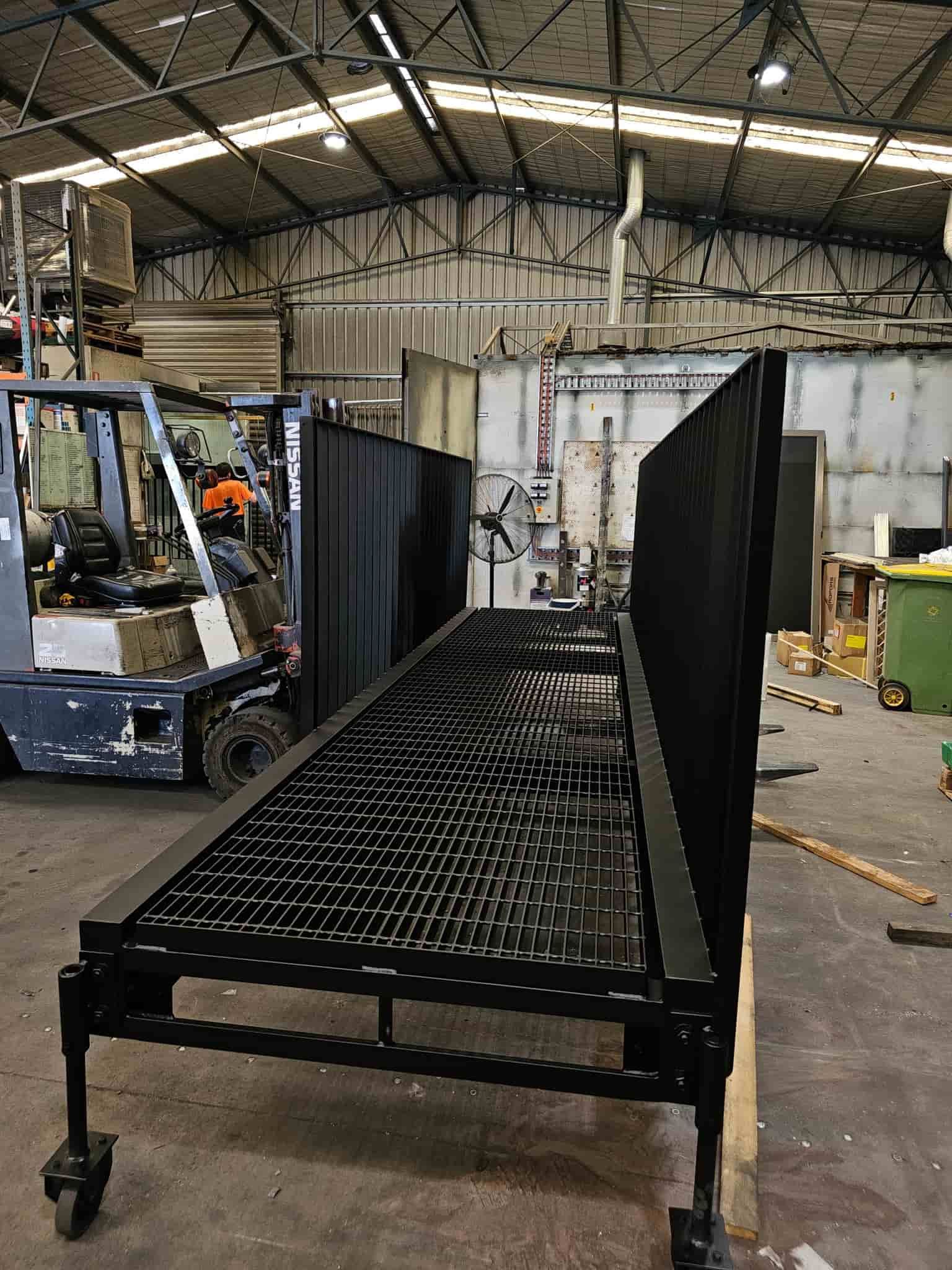 A Forklift Is Driving Down A Ramp — Border Security Doors & Powder Coating in Wodonga, VIC