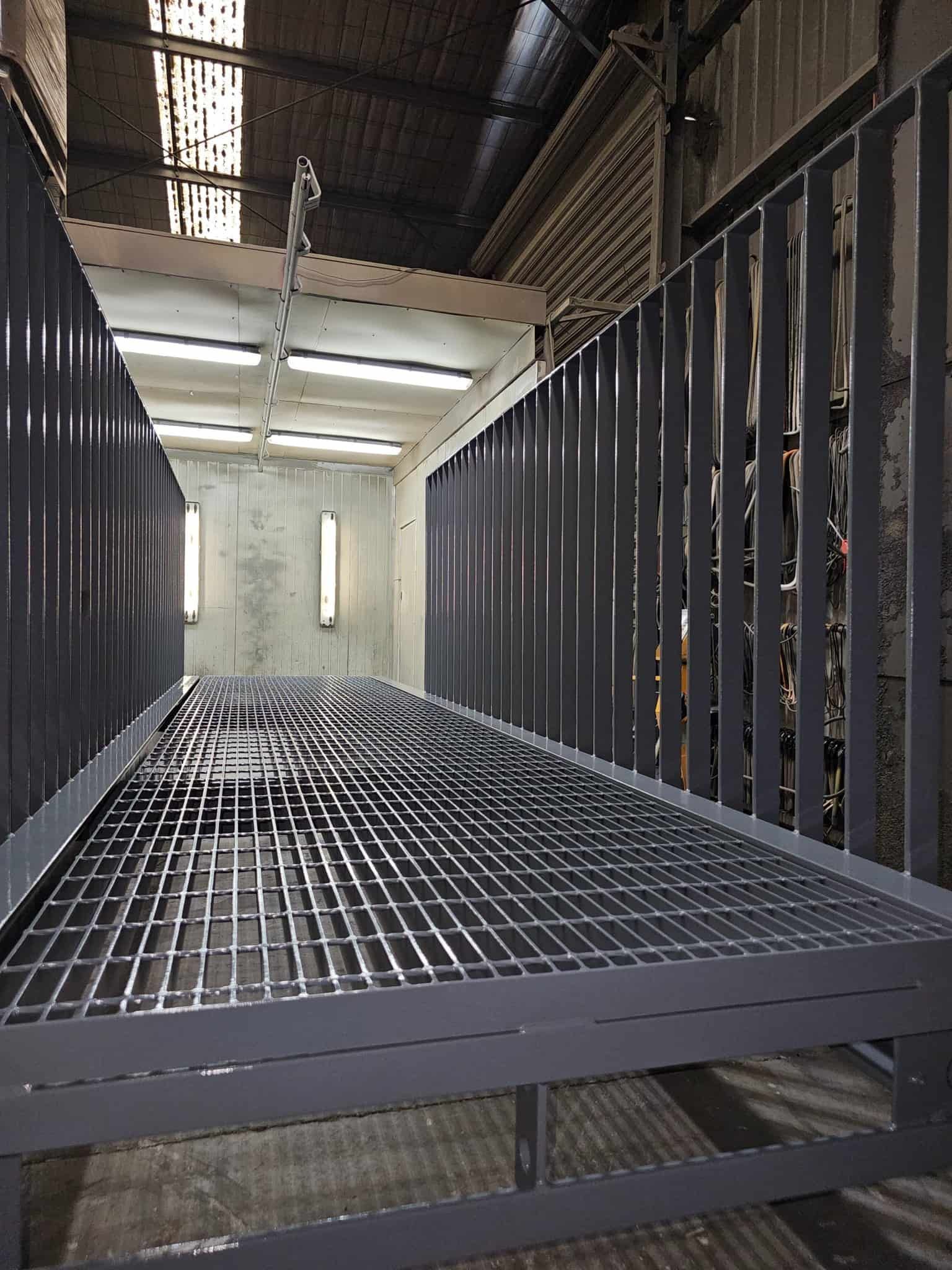 A Metal Staircase In A Warehouse With A Railing — Border Security Doors & Powder Coating in Wodonga, VIC
