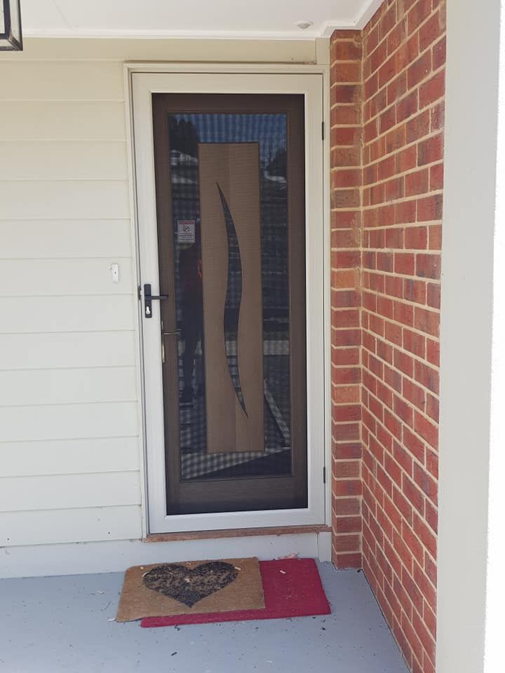 A Door With A Heart On It Is Next To A Brick Wall — Border Security Doors & Powder Coating in Wangaratta, NSW