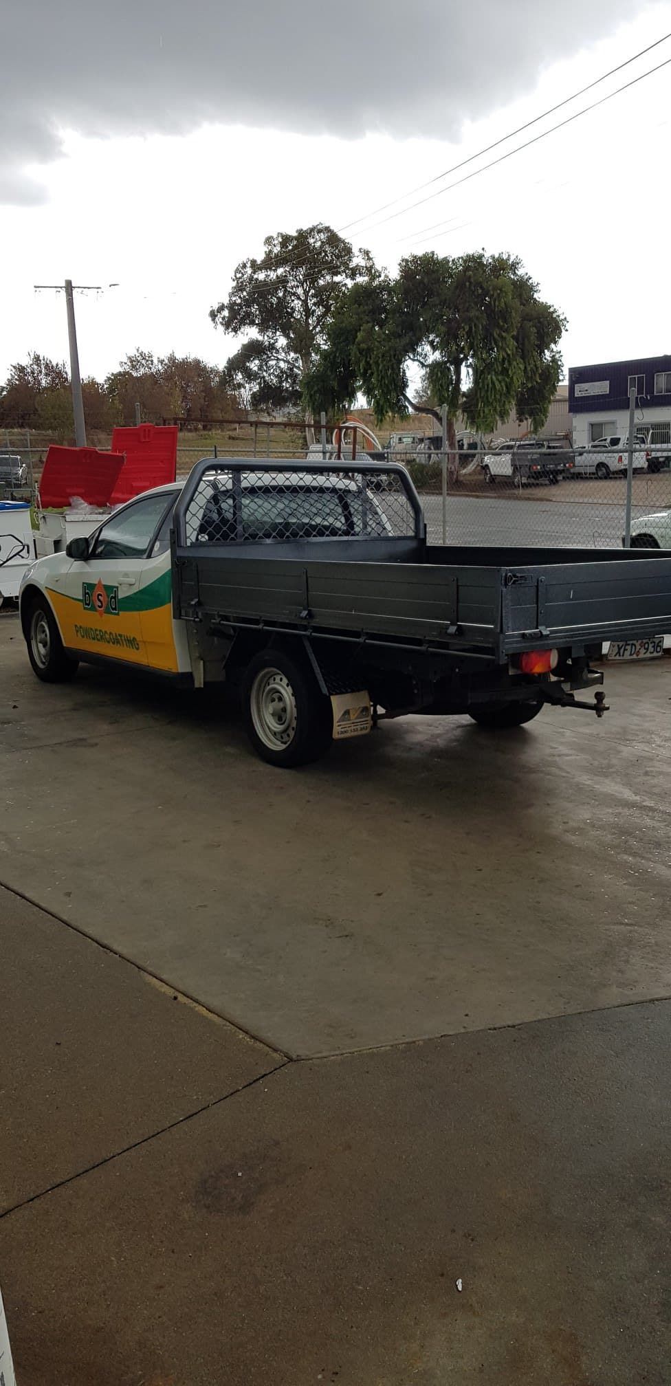 A Yellow And Black Truck Is Parked In A Parking Lot — Border Security Doors & Powder Coating in Wodonga, VIC