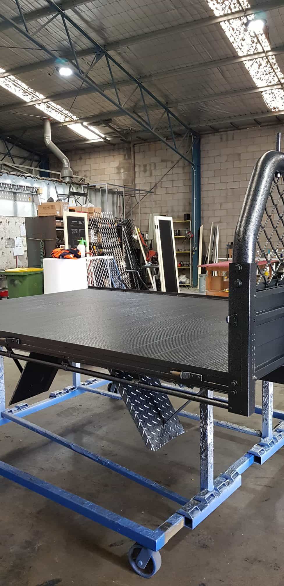 A Truck Bed Is Sitting On Top Of A Blue Cart — Border Security Doors & Powder Coating in Wodonga, VIC