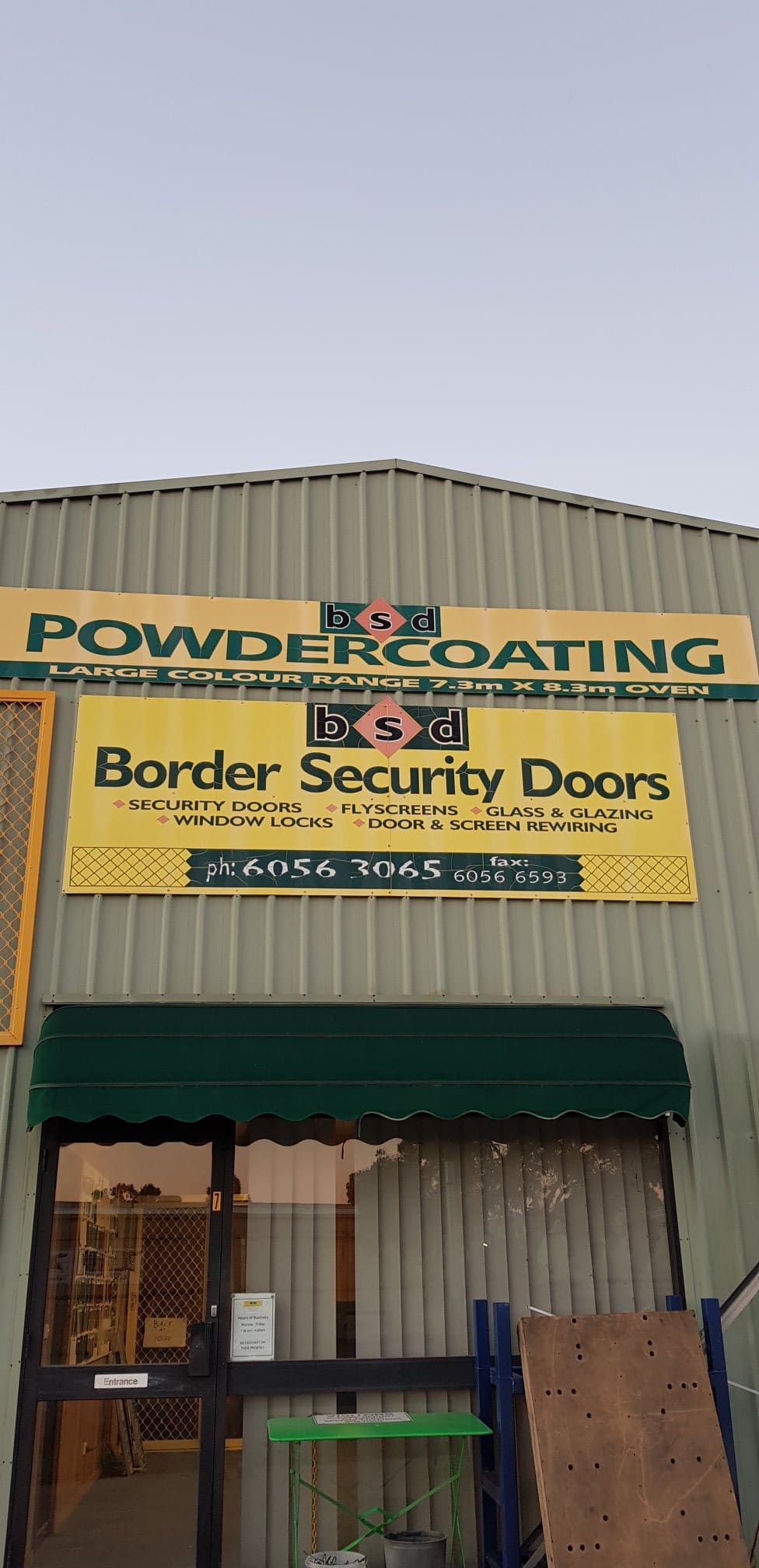 A Building With A Sign — Border Security Doors & Powder Coating in Wodonga, VIC