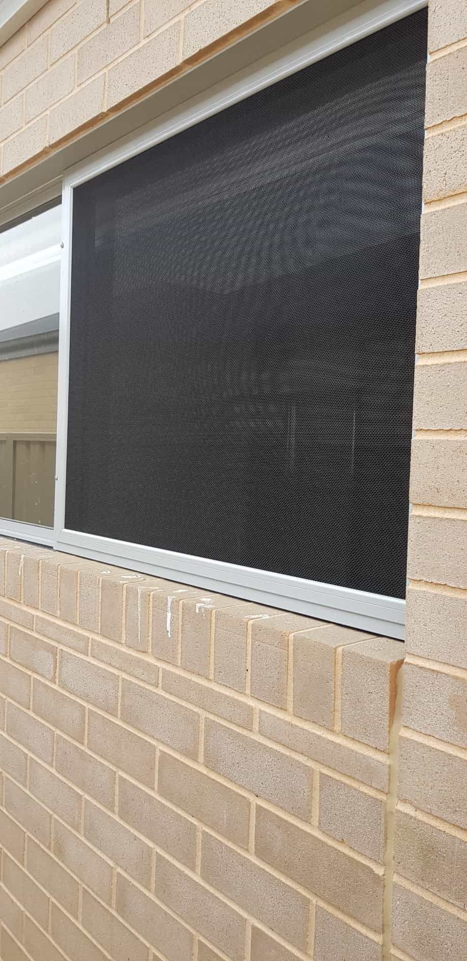 A Brick Wall With A Window — Border Security Doors & Powder Coating in Wodonga, VIC
