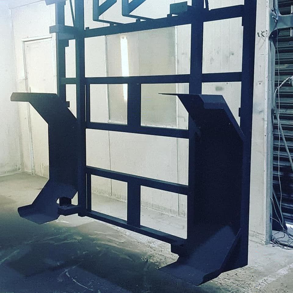 A Black Metal Structure Is Hanging — Border Security Doors & Powder Coating in Wodonga, VIC