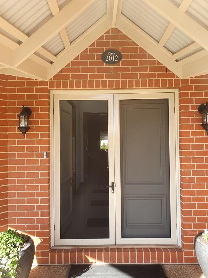 A Brick Building With Open Window — Border Security Doors & Powder Coating in Wodonga, VIC