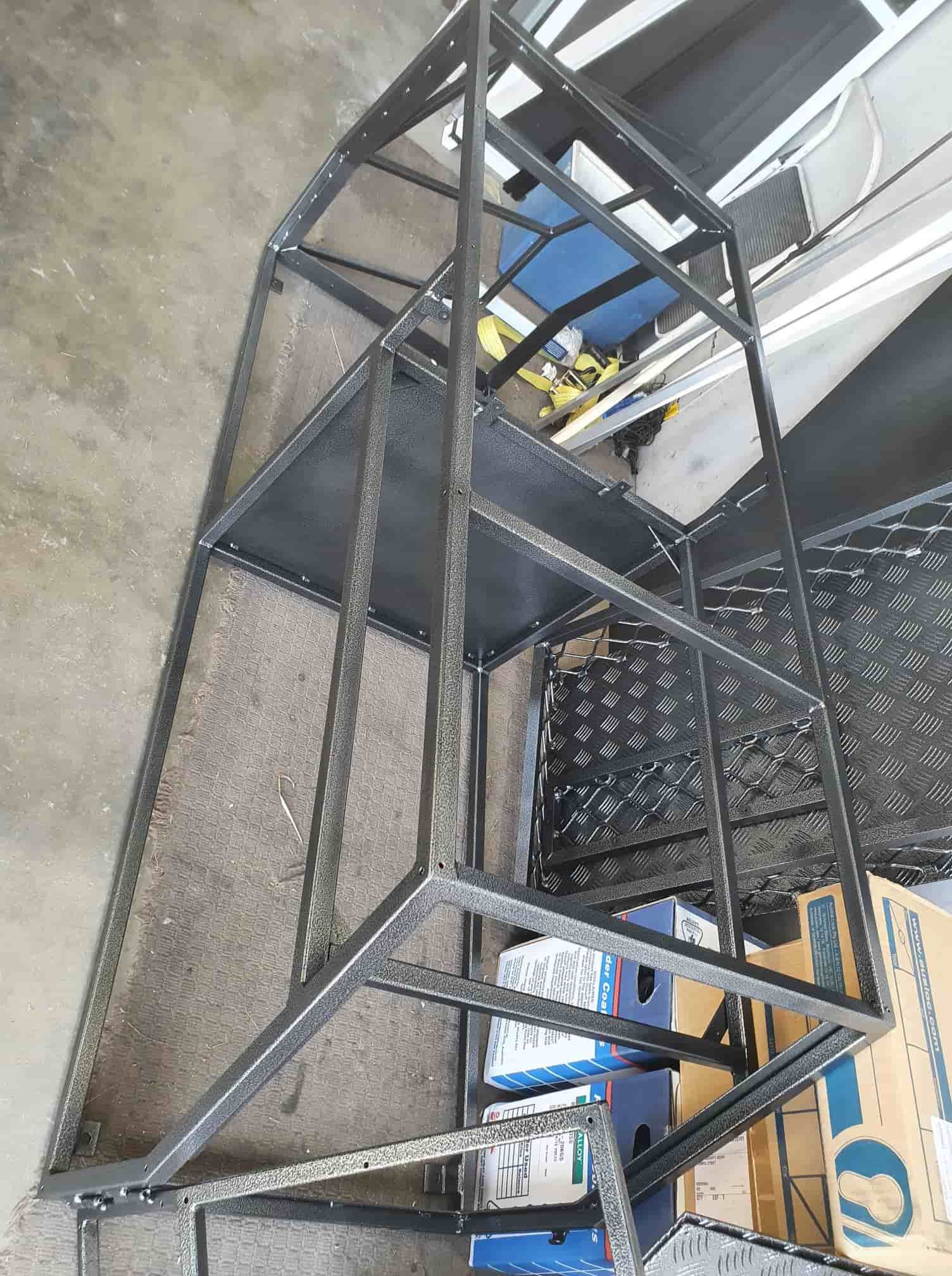 A Metal Ladder Is Sitting On Top Of A Concrete Floor — Border Security Doors & Powder Coating in Wodonga, VIC