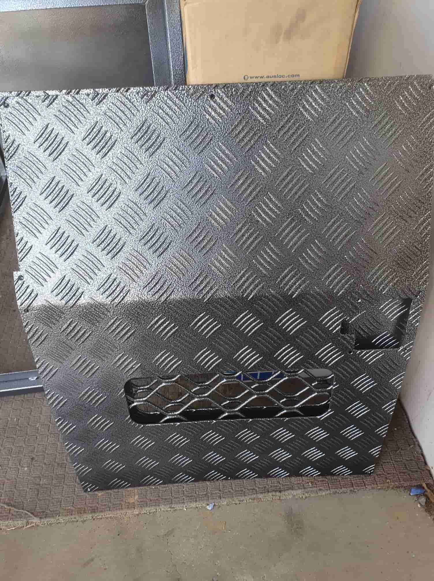 A Piece Of Metal Is Sitting On The Floor Next To A Box — Border Security Doors & Powder Coating in Wodonga, VIC