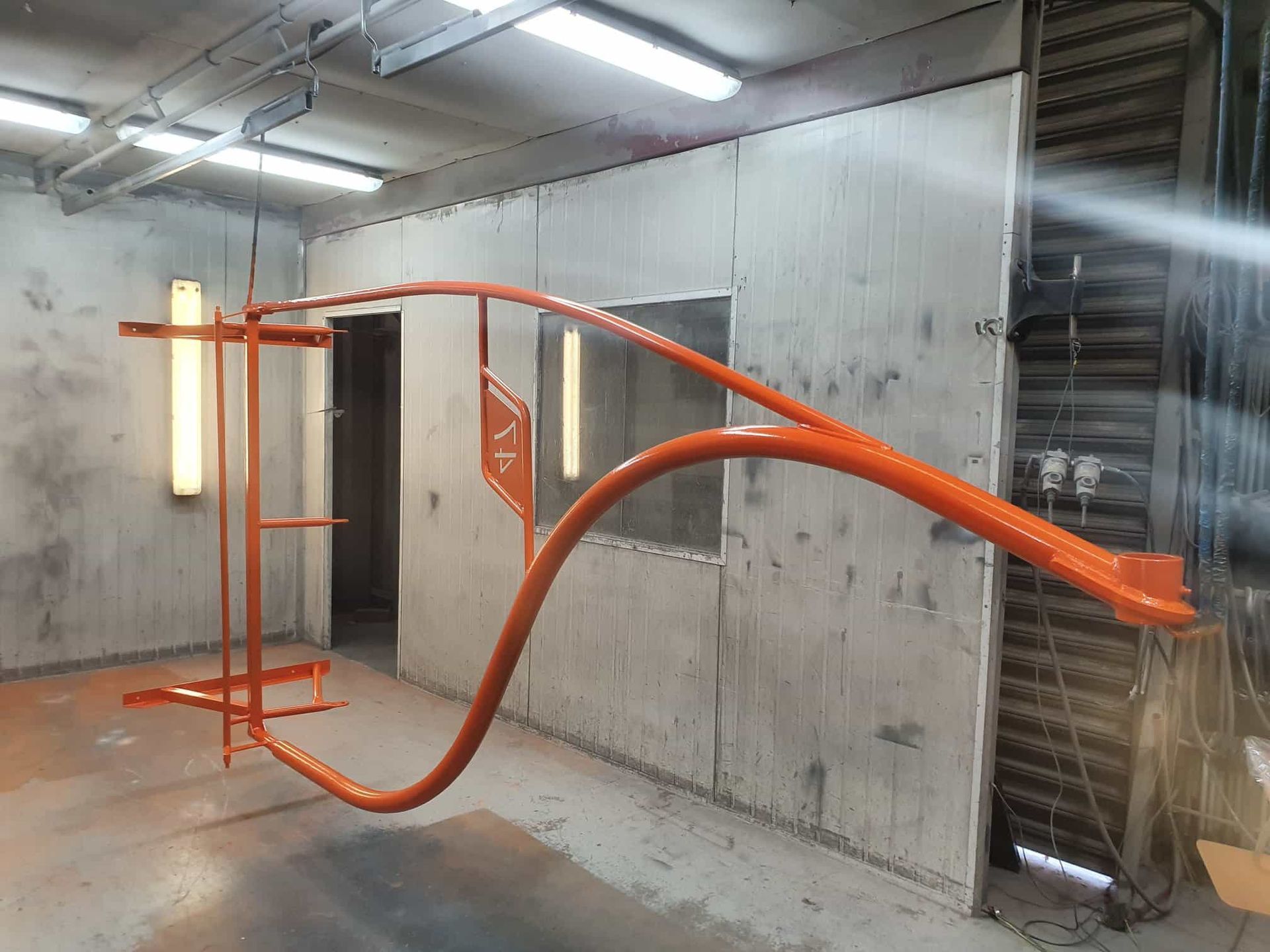 An Orange Pipe Is Hanging From The Ceiling In A Room — Border Security Doors & Powder Coating in Wodonga, VIC
