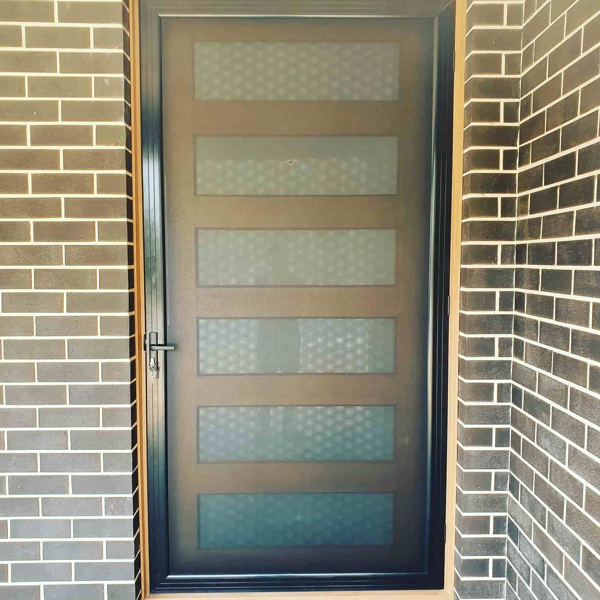 A Brick Wall With A Door In The Corner — Border Security Doors & Powder Coating in Wodonga, VIC