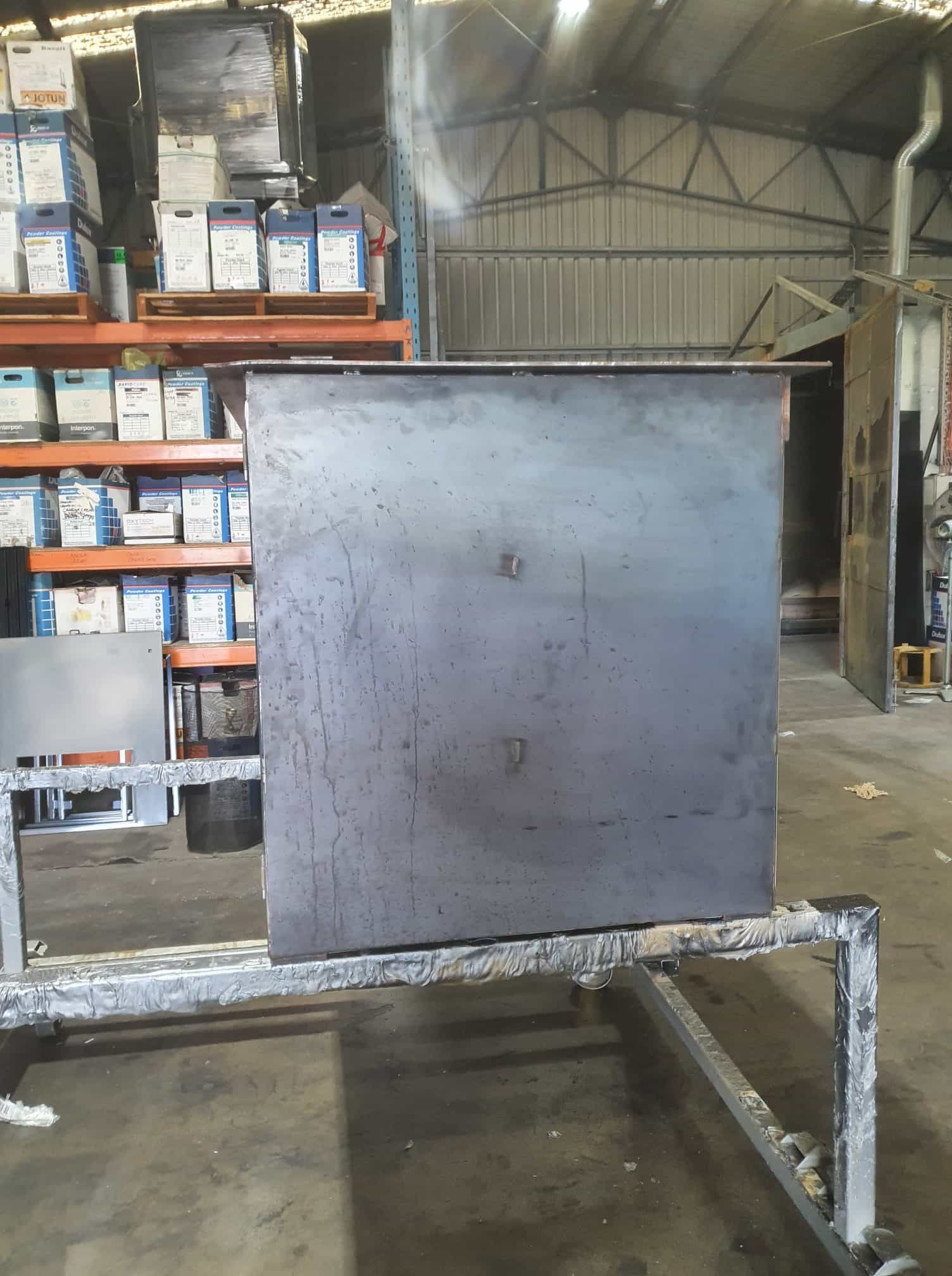 A Metal Box Is Sitting On A Cart In A Warehouse — Border Security Doors & Powder Coating in Wodonga, VIC