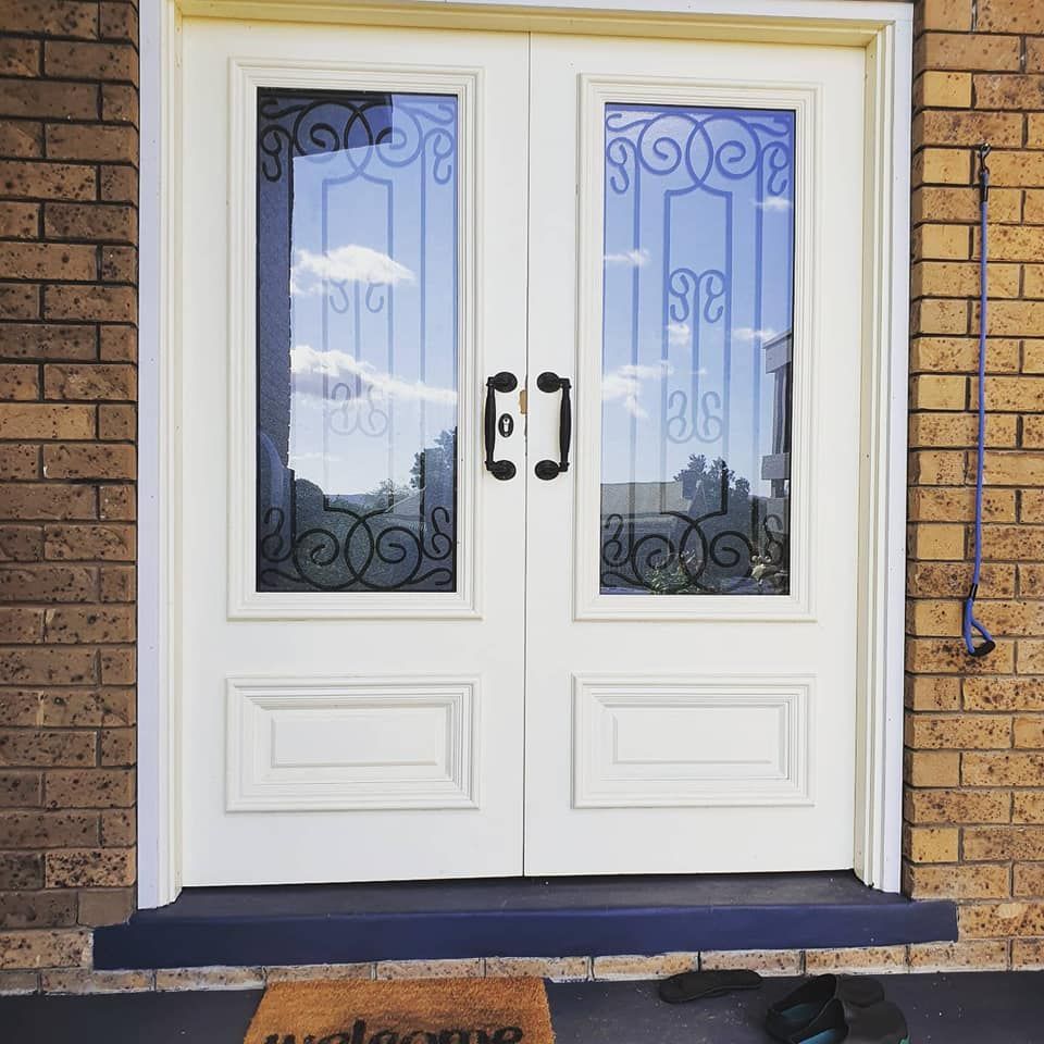 A White Door With A Welcome Mat In Front Of It — Border Security Doors & Powder Coating in Albury, NSW