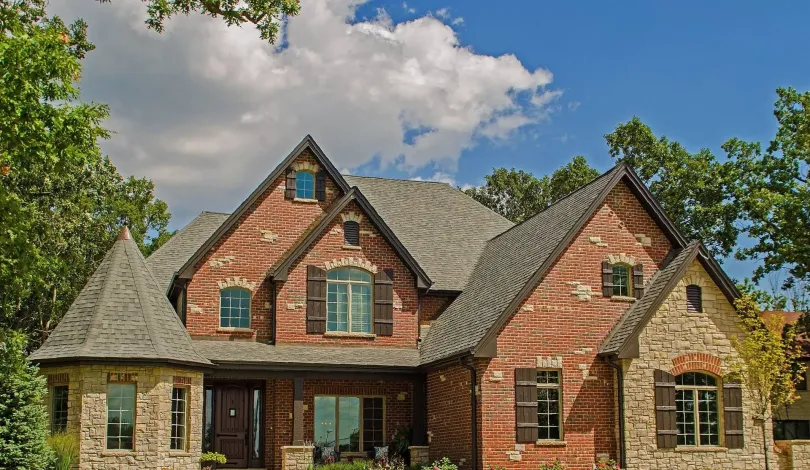 A large brick and stone house with a gray roof