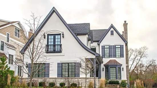 A large white house with black shutters and a black roof.