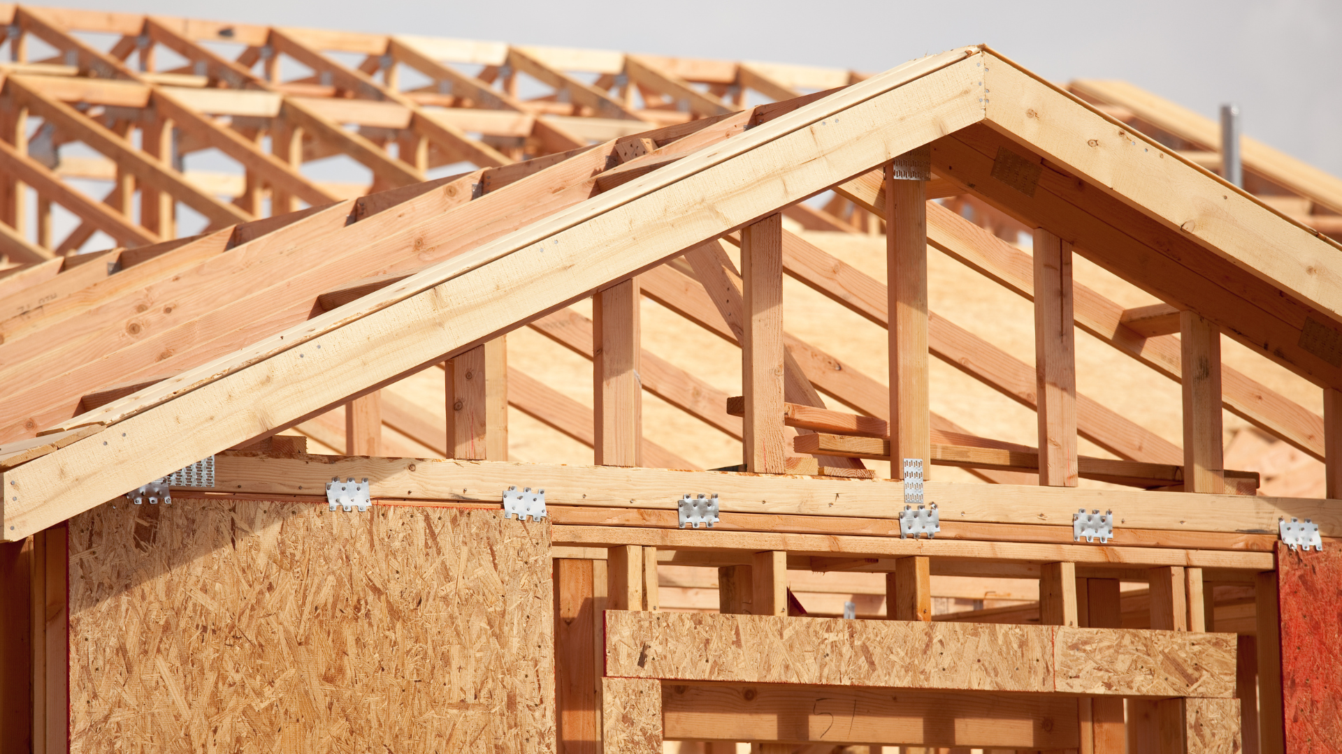 A house is being built with wooden beams and a roof.