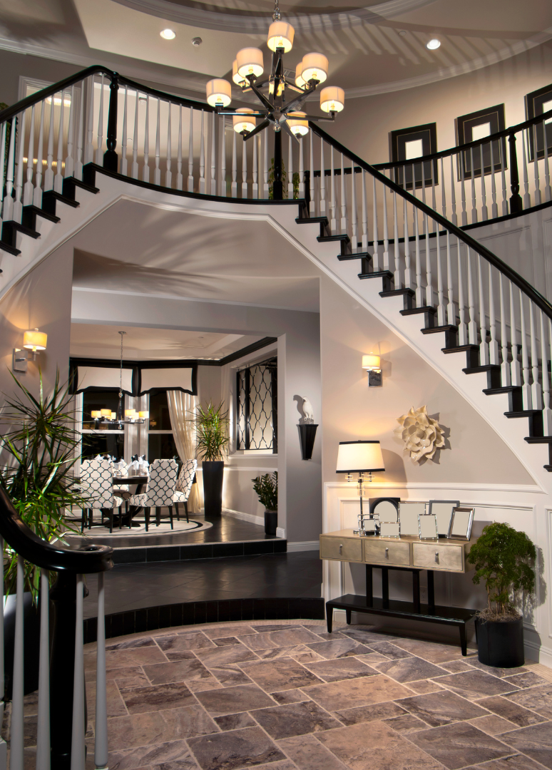 A large staircase in a house with a chandelier hanging from the ceiling