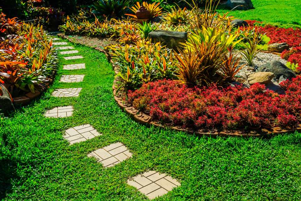 garden stone path with grass growing up between the stone