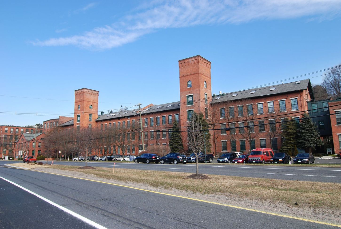 A large brick building with a lot of cars parked in front of it