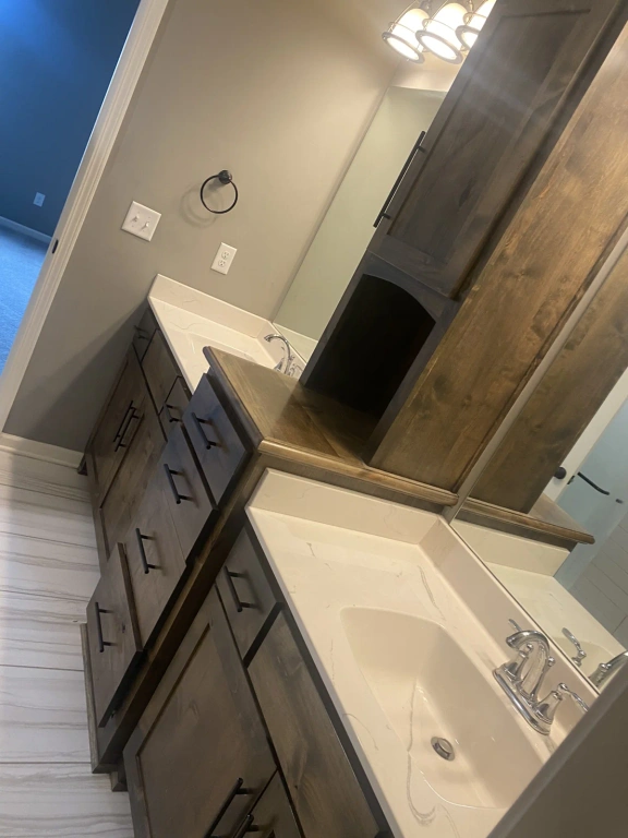 A bathroom with a sink , mirror and cabinets