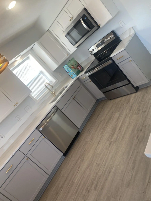 A kitchen with stainless steel appliances and white cabinets