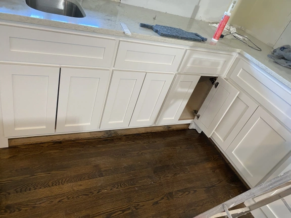 A kitchen with white cabinets and a sink