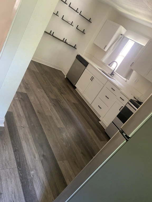 A kitchen with white cabinets and stainless steel appliances