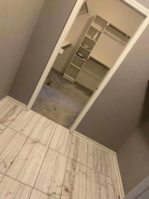 A walk in closet with a marble floor