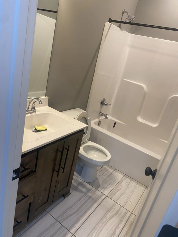 A bathroom with a toilet , sink , bathtub and shower.
