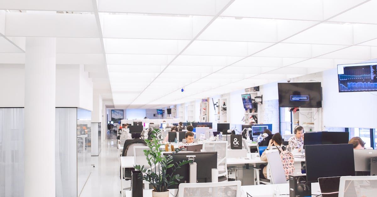A blurry picture of a large office with lots of people working on computers.