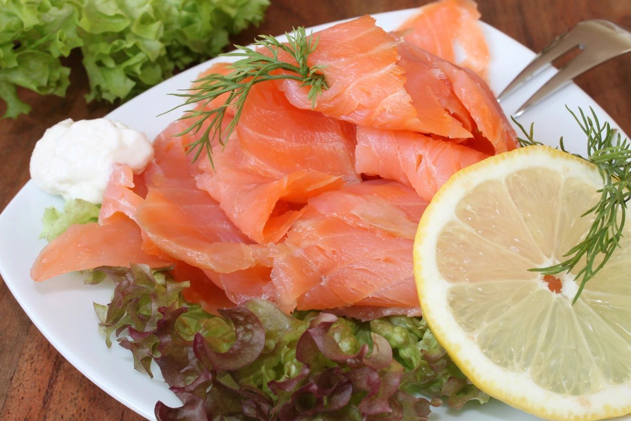 A White Plate Topped With Sliced Salmon And A Slice Of Lemon - Northfield, IL - Be40Strong