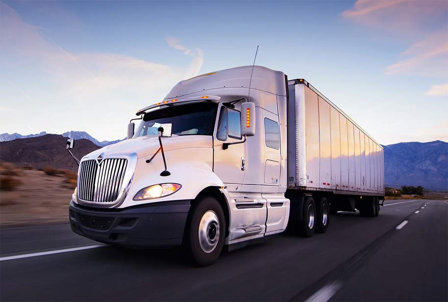 a white semi truck is driving down a highway