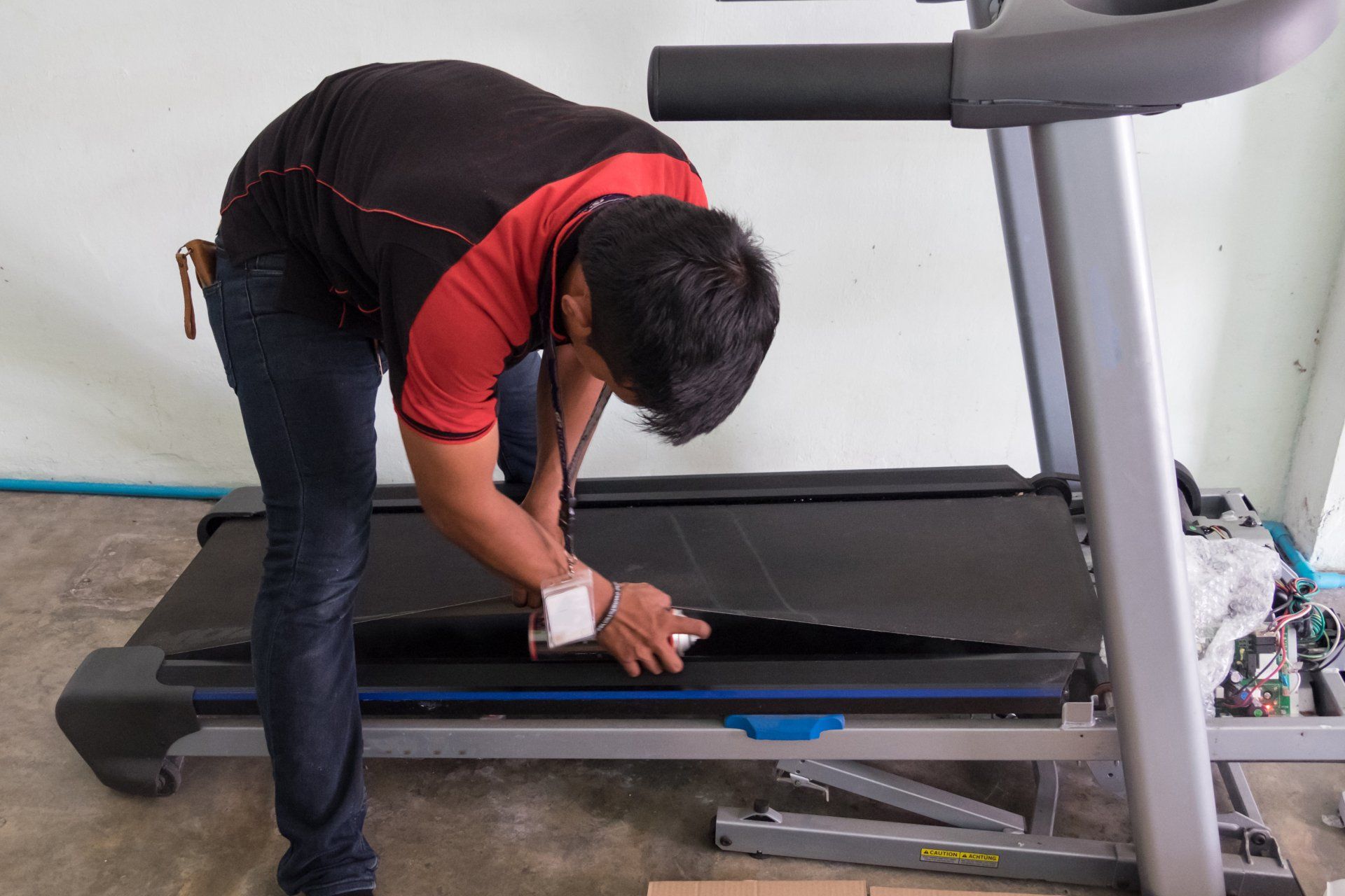 a man is working on a treadmill that has a yellow sticker on it