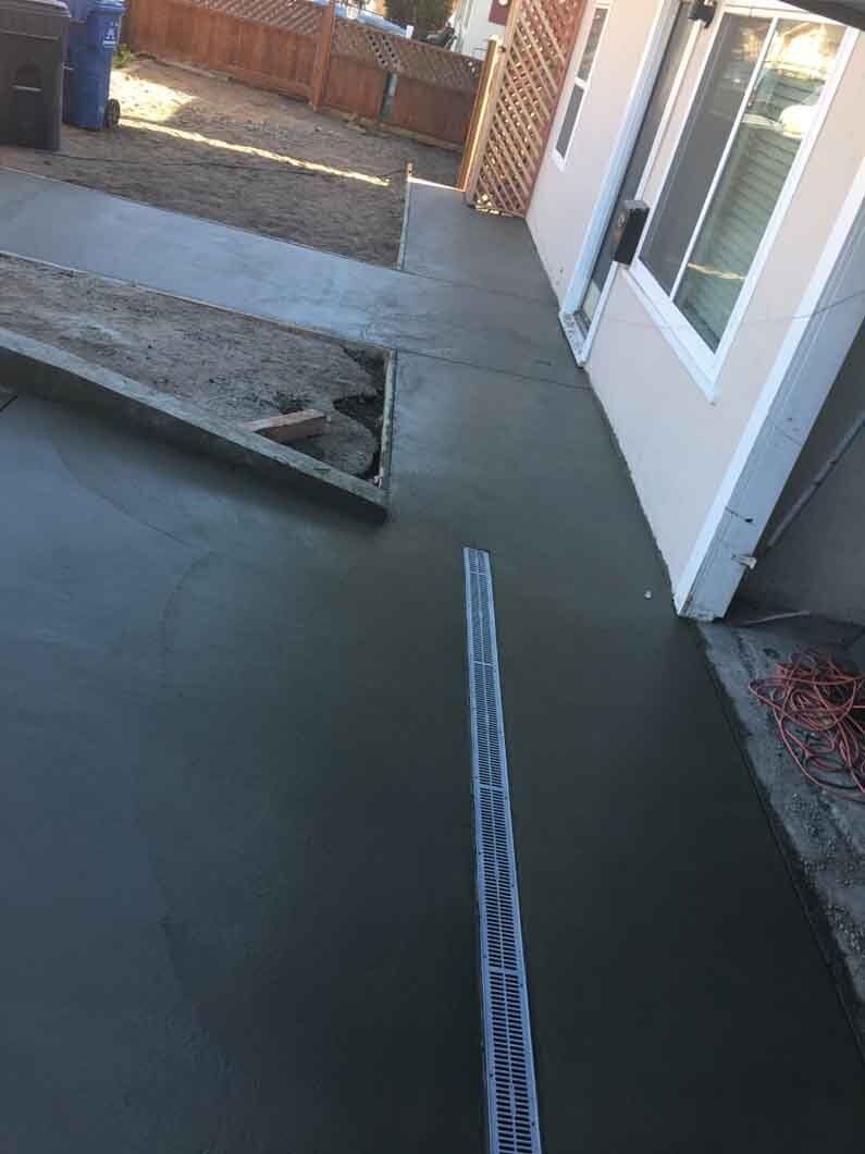A concrete walkway is being built in front of a house.