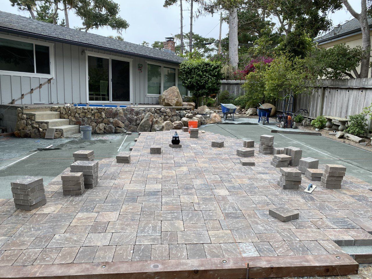 A patio is being built in the backyard of a house.