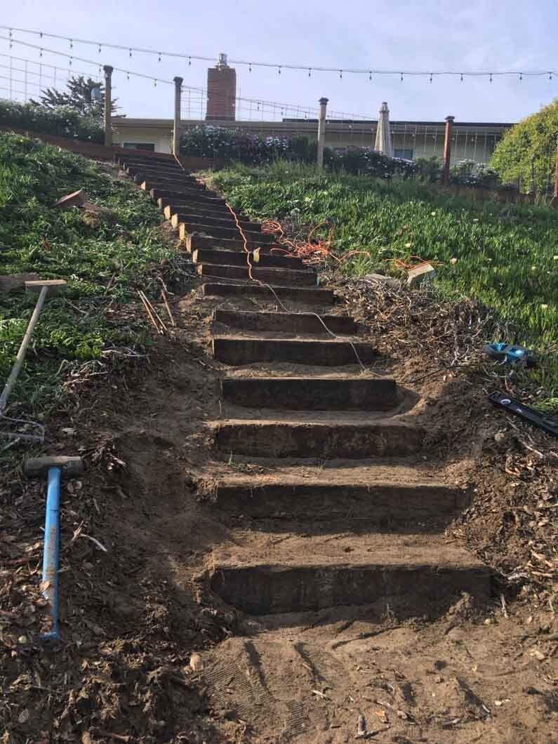A set of stairs going up a hill in the dirt.