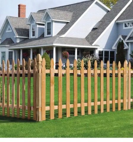 A wooden picket fence in front of a house