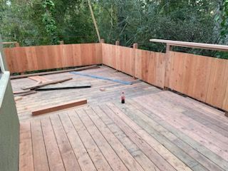 A wooden deck with a wooden fence surrounding it.