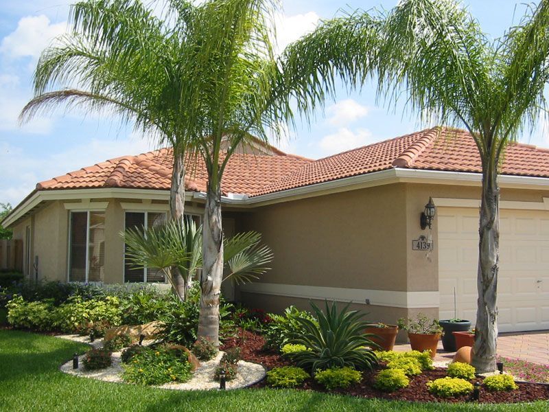 A house with two palm trees in front of it