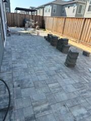 A patio is being built in the backyard of a house.