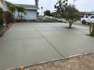 A concrete driveway is being built in front of a house.