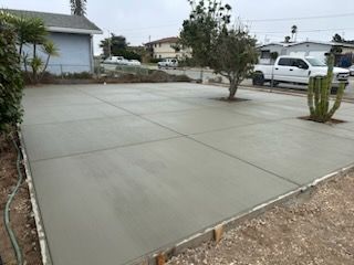 A concrete driveway is being built in front of a house.