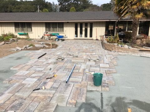 A patio is being built in front of a house.