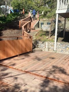 A wooden deck with stairs leading up to a house.