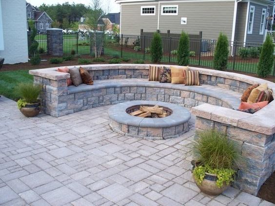 A brick patio with a fire pit in the middle