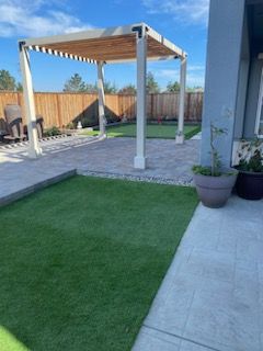There is a pergola in the backyard of a house.