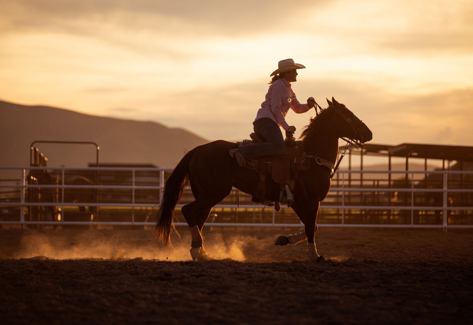 A woman in a cowboy hat is riding a horse