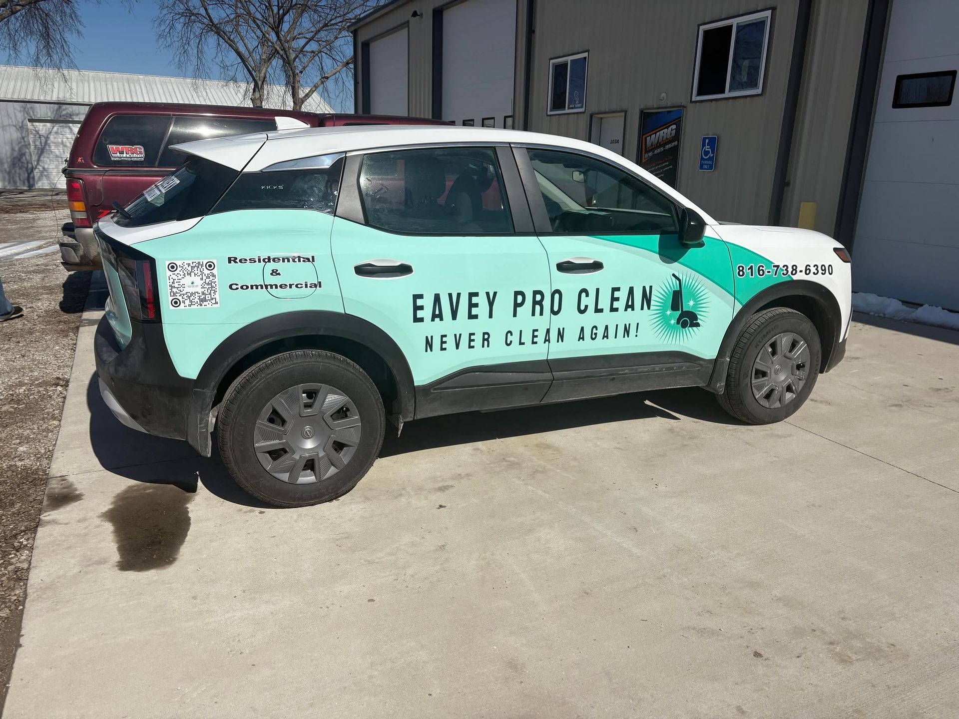 A green and white eavey pro clean car is parked in front of a building.