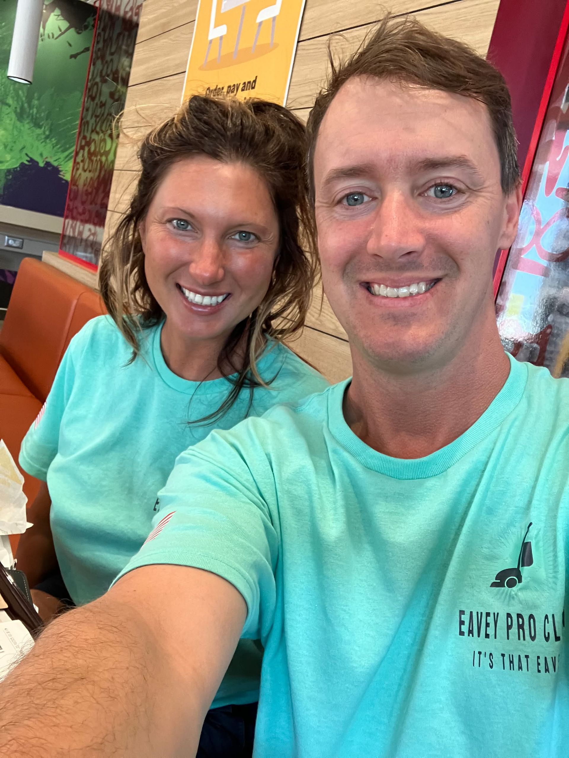A man and a woman are taking a selfie in a restaurant.