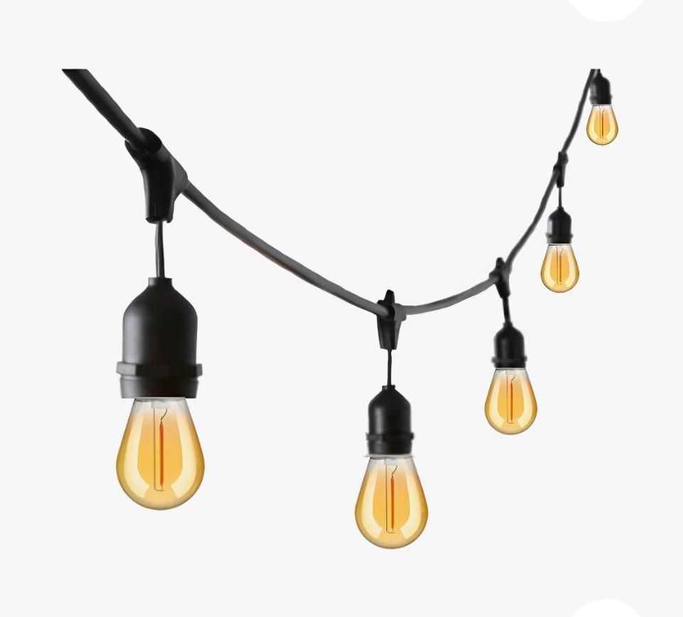Cadena de luces para exterior con bombillas de color ámbar, cable y casquillos negros, sobre fondo blanco.